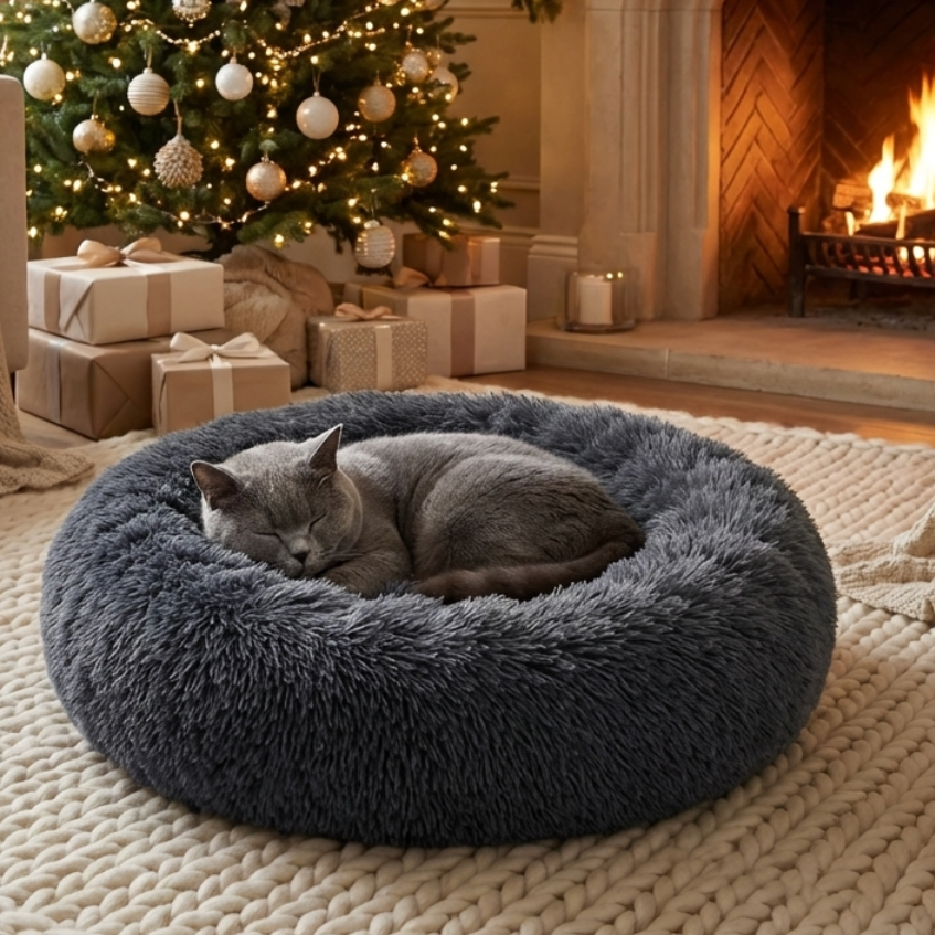Grey cat sleeping in a fluffy grey Cozy Cocoon bed by HappinessPaws™ in front of a Christmas tree and fireplace.