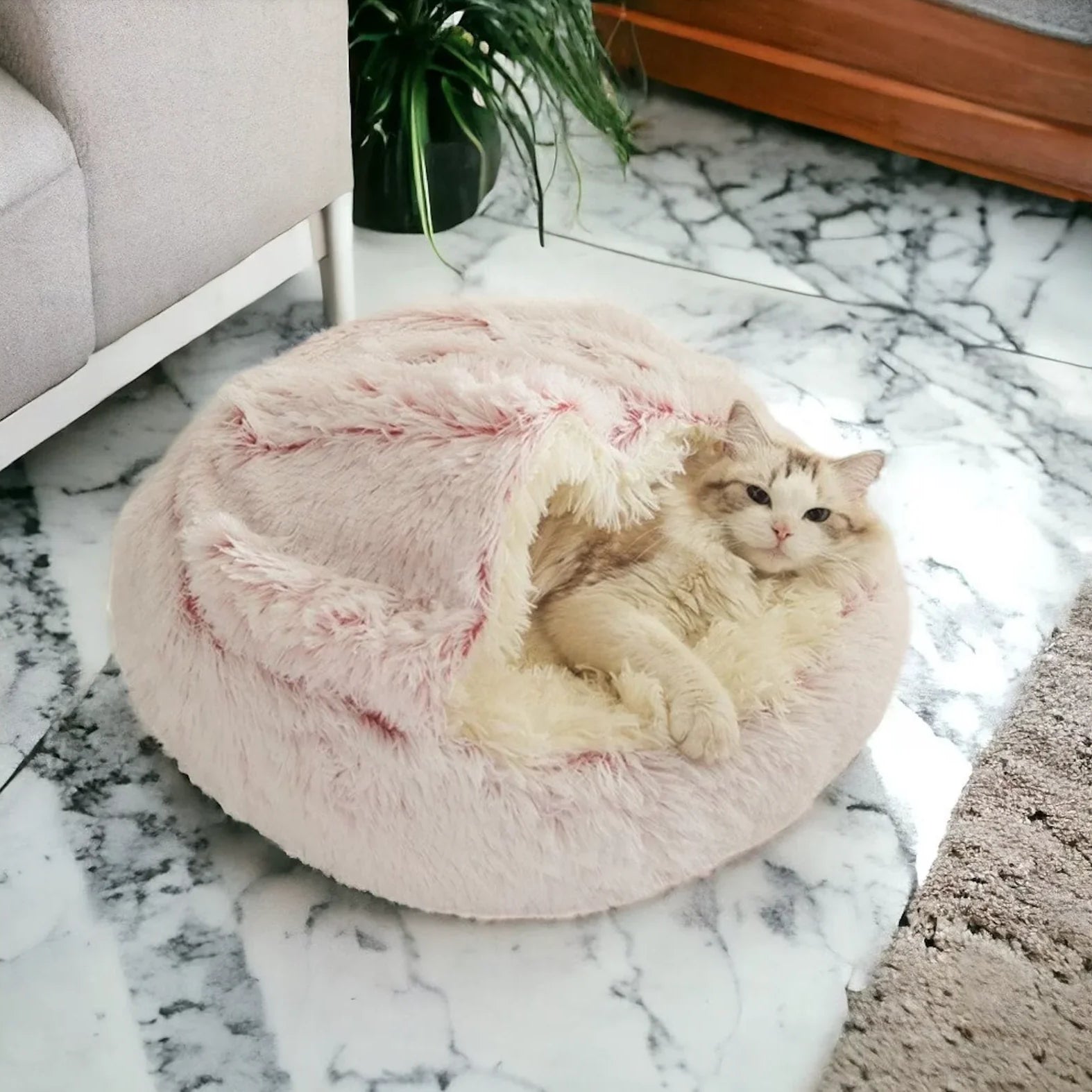 Cat relaxing inside a pink fluffy cozy cocoon bed on a marble floor, soft and comfortable sleeping space