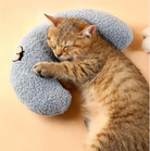 A relaxed tabby cat snuggled up to a blue HappinessPaws calming pillow