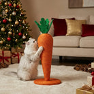 Cat playing with a carrot-shaped scratching post in a living room with a Christmas tree and presents.