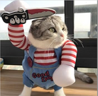 Cat wearing a Chucky costume with red-striped arms, holding a toy knife raised in the air.