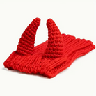 Red knitted horns on a white background