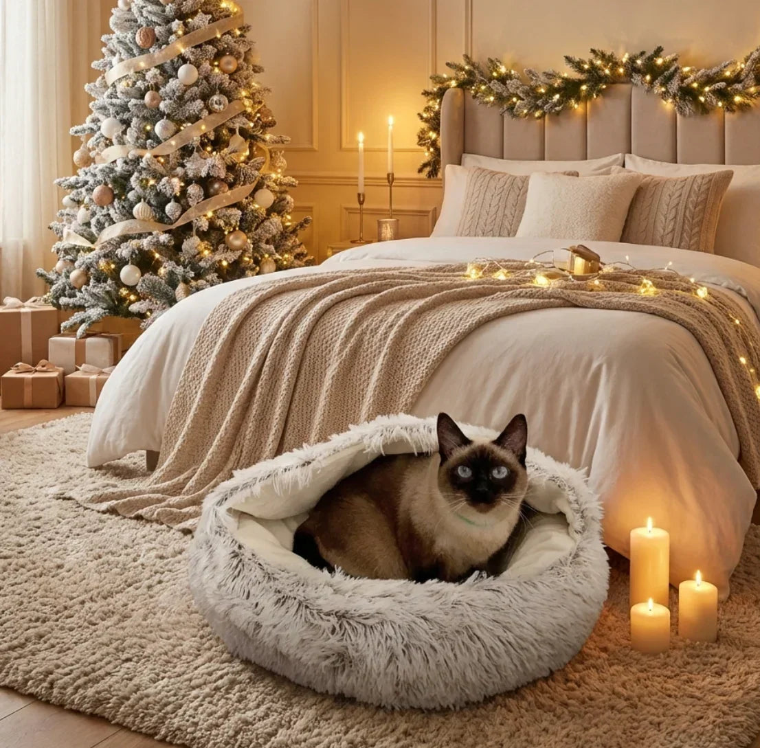 Cozy bedroom with a Siamese cat in a fluffy pet bed, Christmas tree, and decorations.