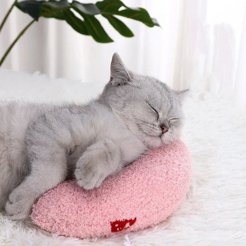 Gray cat enjoying a peaceful nap on a pink HappinessPaws calming pillow