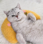 Gray cat resting on a yellow HappinessPaws calming pillow for ultimate relaxation